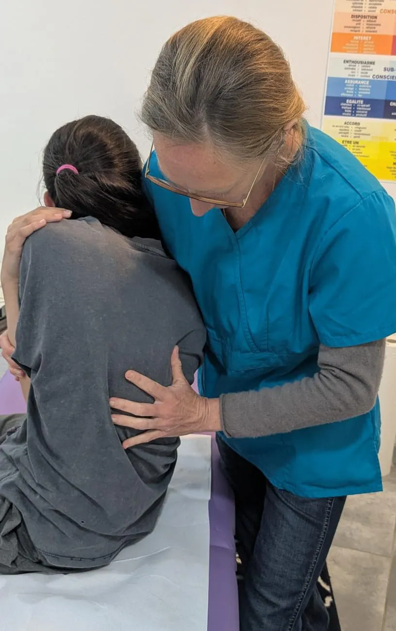 Céline Rochet en consultation, main sur le dos d'une patiente