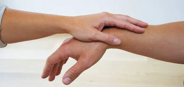 Test musculaire en kinésiologie — main qui teste l'avant-bras